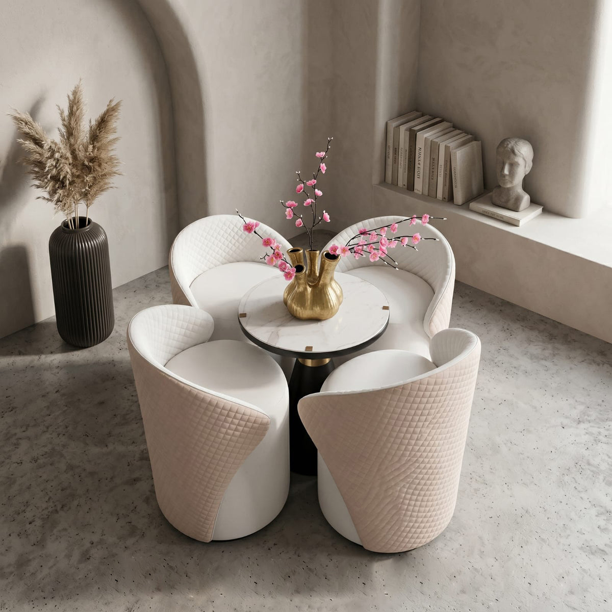Four modern curved dining chairs arranged around a small round table in a minimalist interior setting with a vase, books, and a bust sculpture.